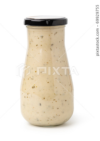 Closed glass jar of white garlic and herb sauce 69929755