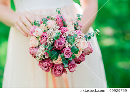 Wedding bouquet of white and red roses in bride's hands Wedding bouquet of white and red roses in bride's hands 69929769