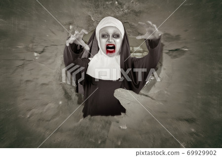 Scary devil nun coming out from a hole Scary devil nun coming out from a hole 69929902