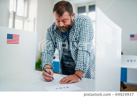 Portrait of man voter in polling place, usa elections concept. Portrait of man voter in polling place, usa elections concept. 69929937
