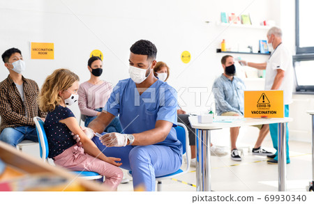 Child with face mask getting vaccinated, coronavirus, covid-19 and vaccination concept. 69930340