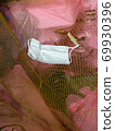 A mask that had fallen on the net stretched in the garbage dump 69930396