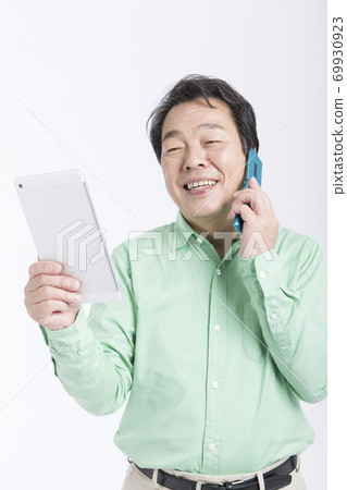 一個人看著平板電腦打電話 69930923