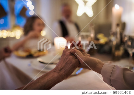 Close-up of hands holding together at the table at Christmas. 69931408
