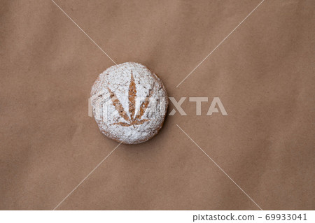 Pattern of cannabis leaf made with powdered sugar on the cookies on kraft background. Cannabis live resin extraction. Banner 69933041