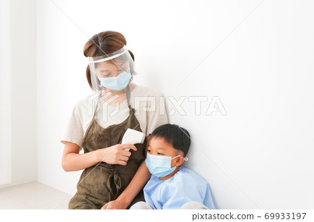 測量嬰兒體溫的托兒所老師 69933197