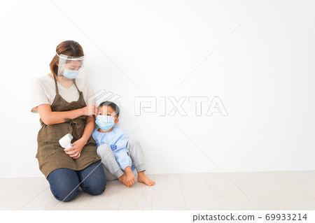 A nursery teacher who measures the temperature of an infant A nursery teacher who measures the temperature of an infant 69933214