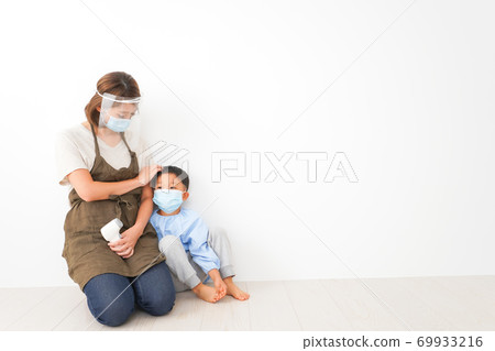 A nursery teacher who measures the temperature of an infant A nursery teacher who measures the temperature of an infant 69933216