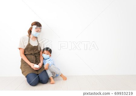 A nursery teacher who measures the temperature of an infant A nursery teacher who measures the temperature of an infant 69933219