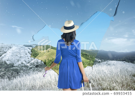 Asian woman with a suitcase looking at landscapes with winter and summer climate Asian woman with a suitcase looking at landscapes with winter and summer climate 69933455