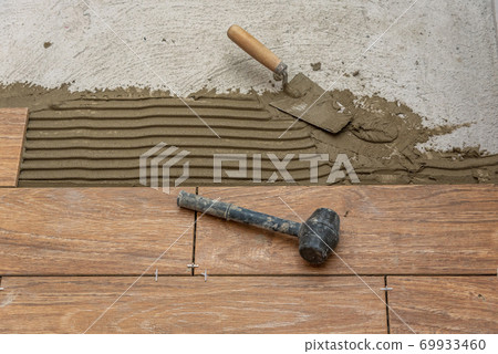 Worker placing ceramic. Worker placing ceramic. 69933460