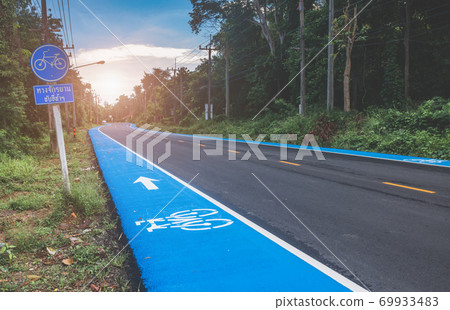 Asphalt road with blue side pavement for bicycle lane. Asphalt road with blue side pavement for bicycle lane. 69933483