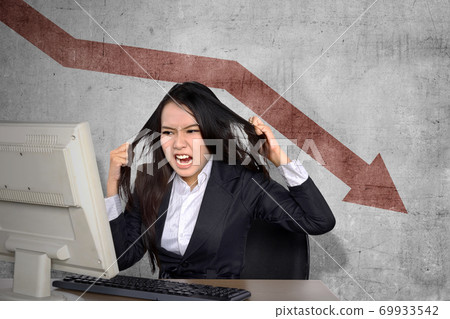 Asian businesswoman feeling depressed looking global economic impact report on the computer Asian businesswoman feeling depressed looking global economic impact report on the computer 69933542
