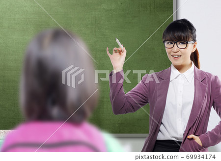 Asian teacher woman with marker standing in the classroom with a chalkboard background 69934174
