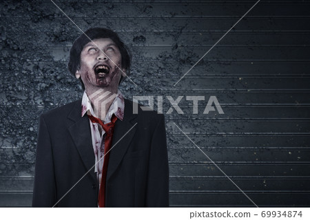 Scary zombie with blood and wound on his body 69934874