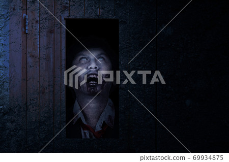 Scary zombie standing behind the door 69934875