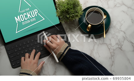 Female hands typing on mock up digital tablet on marble desk 69935804
