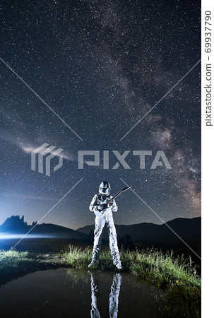 Space traveler playing guitar under beautiful night sky. Space traveler playing guitar under beautiful night sky. 69937790