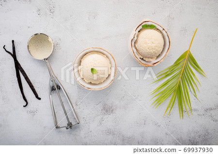 Coconut ice cream flavours in half of coconut setup on white stone background. Summer and Sweet menu concept. Coconut ice cream flavours in half of coconut setup on white stone background. Summer and Sweet menu concept. 69937930