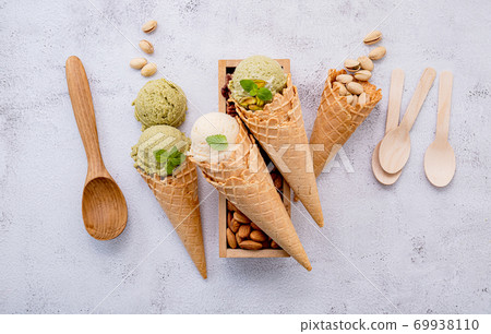 Pistachio and vanila ice cream in cones  with mixed nut setup on 69938110