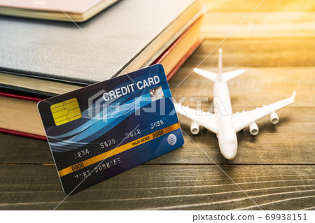 Credit card and airplane model on wooden table 69938151