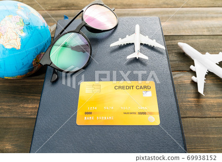 Credit card and airplane model on wooden table 69938152