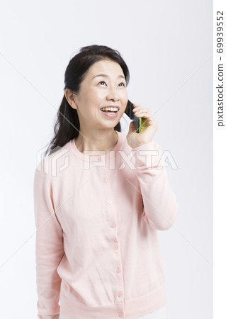A woman talking on a mobile phone A woman talking on a mobile phone 69939552