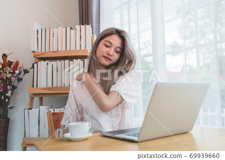 Lazy bored asian woman using laptop in the morning. Lazy bored asian woman using laptop in the morning. 69939660