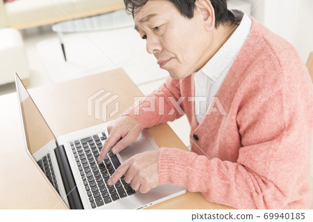 Middle man playing a laptop Middle man playing a laptop 69940185