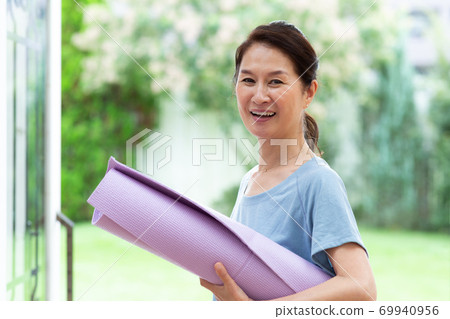 A beautiful woman in her 60s enjoying yoga 69940956