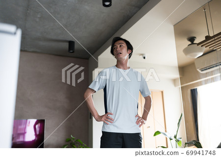 A man doing gymnastics at home A man doing gymnastics at home 69941748