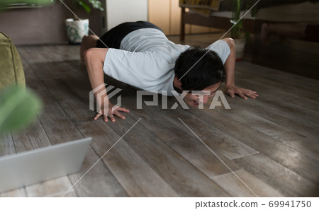 A man doing muscle training in the room A man doing muscle training in the room 69941750