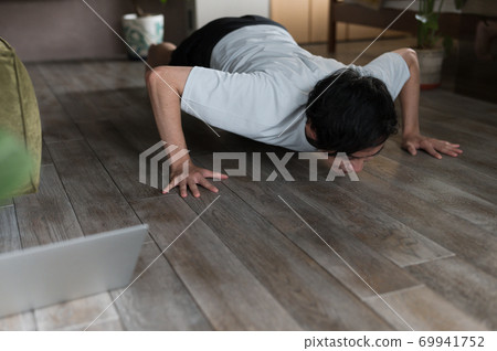 一個男人在房間裡鍛煉肌肉 一個男人在房間裡鍛煉肌肉 69941752