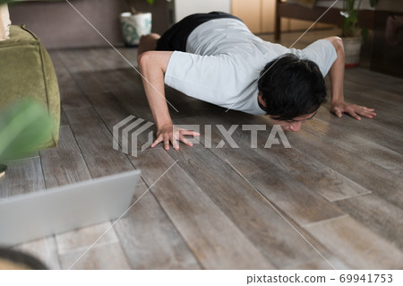 一個男人在房間裡鍛煉肌肉 一個男人在房間裡鍛煉肌肉 69941753