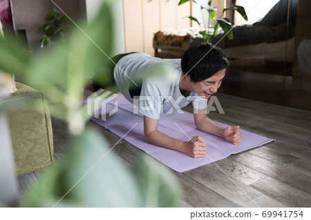一個男人在房間裡鍛煉肌肉 69941754