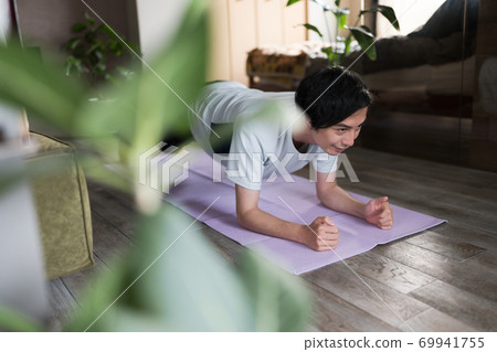 一個男人在房間裡鍛煉肌肉 一個男人在房間裡鍛煉肌肉 69941755