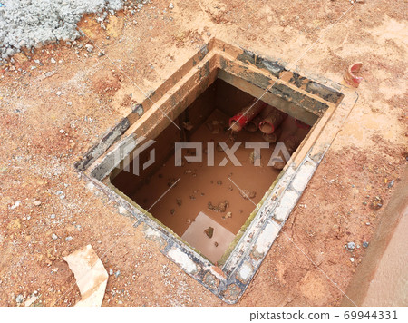 SEREMBAN, MALAYSIA -AUGUST 6, 2020: Utility services manhole and underground pipes under construction at the construction site. In-situ construction by workers based on infrastructure engineer design. 69944331