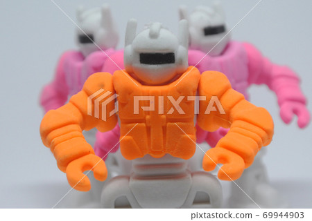 Orange, pink and blue small toy robot made from eraser rubber isolate on white background. 69944903