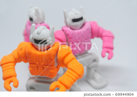 Orange, pink and blue small toy robot made from eraser rubber isolate on white background. Orange, pink and blue small toy robot made from eraser rubber isolate on white background. 69944904