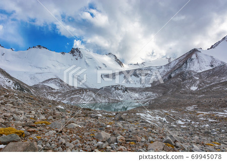 Mountain landscape view in Kyrgyzstan. Rocks, snow and stones in mountain valley view. Mountain panorama. 69945078