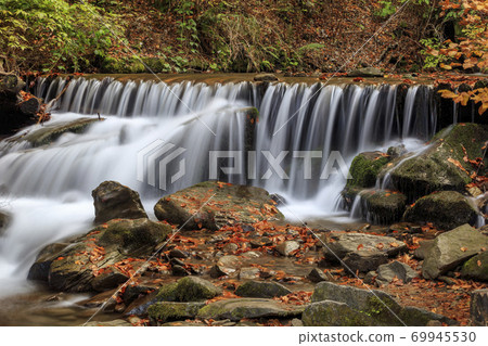 Beautiful streams and small waterfalls near the big Carpathian waterfall Shypit. In the autumn. Beautiful streams and small waterfalls near the big Carpathian waterfall Shypit. In the autumn. 69945530