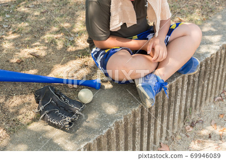 Elementary school students taking a break during baseball practice 69946089