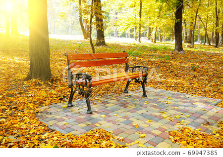 Autumn park, garden bench and bright sunset. Autumn park, garden bench and bright sunset. 69947385