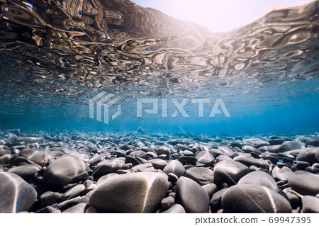 Underwater view with stones, reflection and blue sea water. 69947395