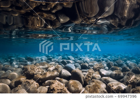 Underwater view with stones, reflection and blue sea water. Underwater view with stones, reflection and blue sea water. 69947396
