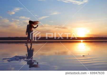 Beautiful young woman with flying red hair on the ocean coast Beautiful young woman with flying red hair on the ocean coast 69947630
