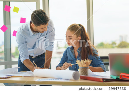Team of multiethnic architects working on construction plans in meeting room. Engineers discussing. Team of multiethnic architects working on construction plans in meeting room. Engineers discussing. 69947888