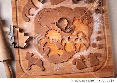 Cutting out shapes from dough for gingerbread Christmas cookies Cutting out shapes from dough for gingerbread Christmas cookies 69949117