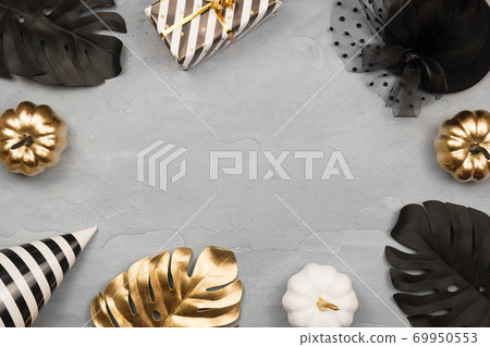 Modern background with black and gold Halloween pumpkin with copy space for text. Flat lay, top view. Modern background with black and gold Halloween pumpkin with copy space for text. Flat lay, top view. 69950553