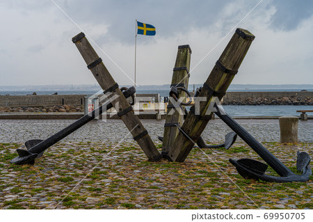 Three old anchors at Parapeten in Helsingborg, Sweden. The anchors represent a long and close relationship with maritime activity. Swedish flag in the background Three old anchors at Parapeten in Helsingborg, Sweden. The anchors represent a long and close relationship with maritime activity. Swedish flag in the background 69950705